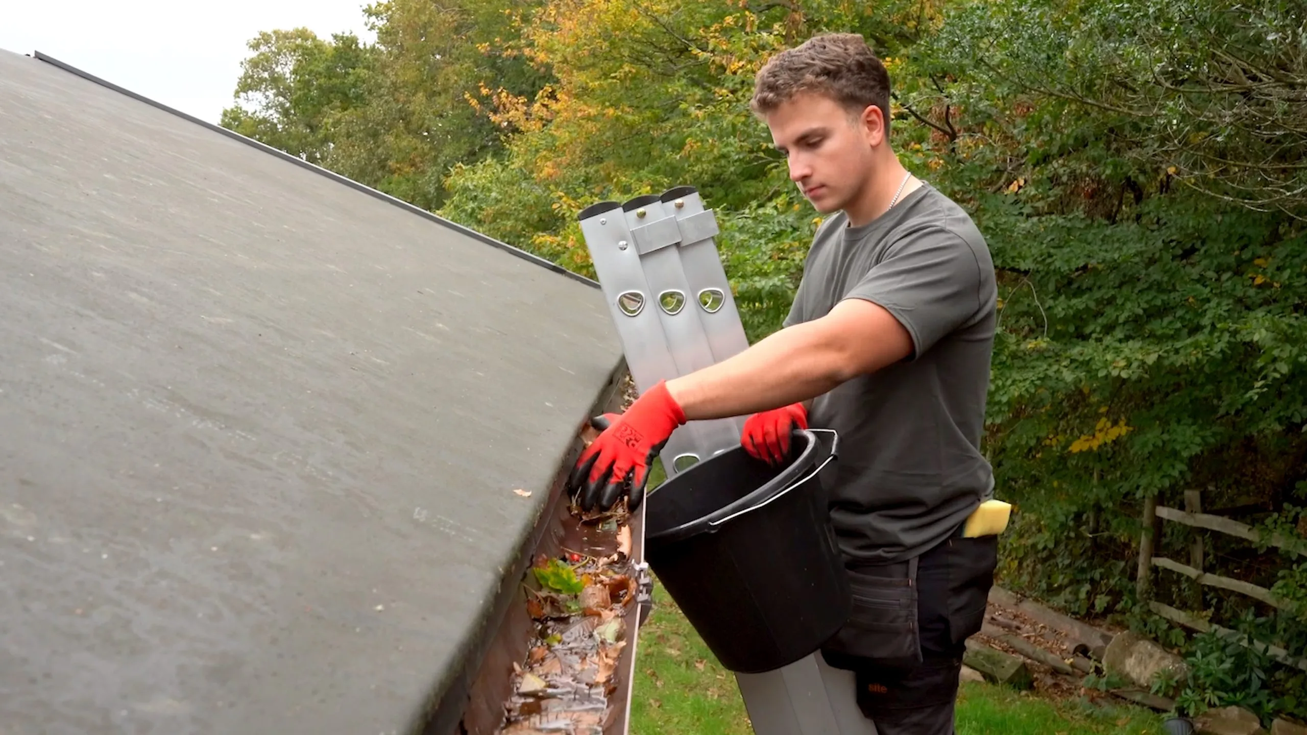 Kent gutter cleaning technician removing debris from a blocked gutter